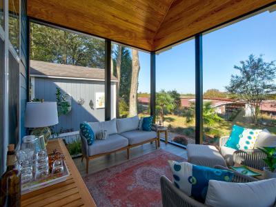 View of the inside of a screened back porch facing the couch.