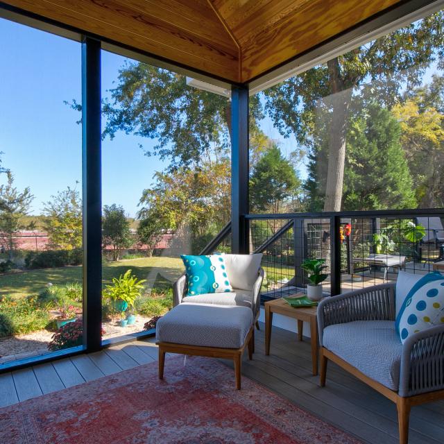 View of the inside of a screened back porch facing the chairs.