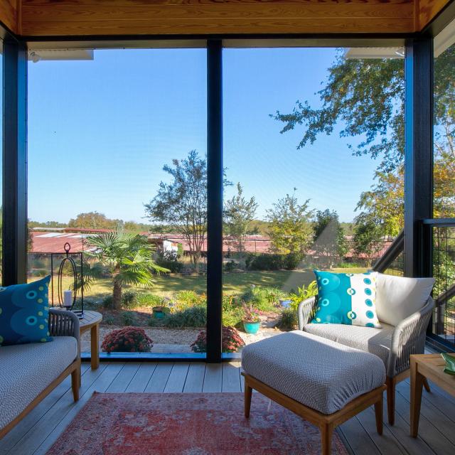 View of the inside of a screened back porch facing the backyard. 