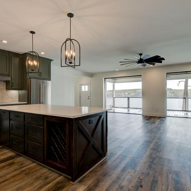 Custom Rafter B kitchen featuring stone countertops and stainless steel appliances in a lakeside home