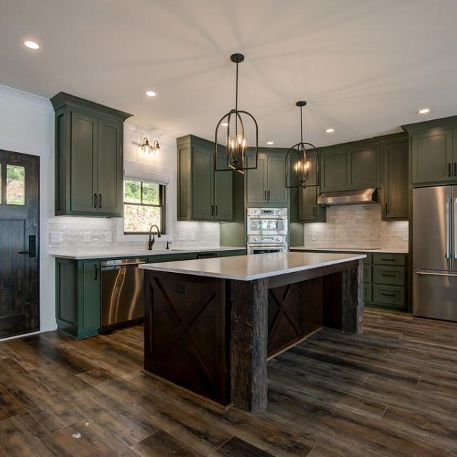 Custom Rafter B kitchen featuring stone countertops and stainless steel appliances in a lakeside home