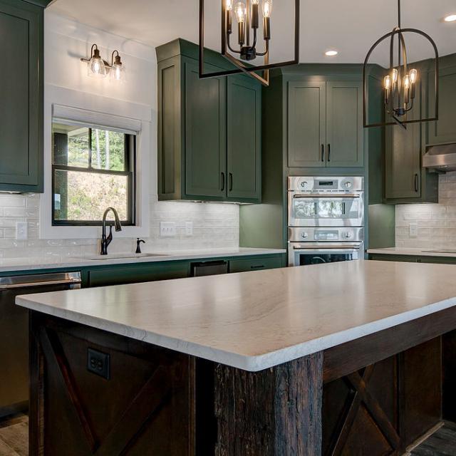 Custom Rafter B kitchen featuring stone countertops and stainless steel appliances in a lakeside home