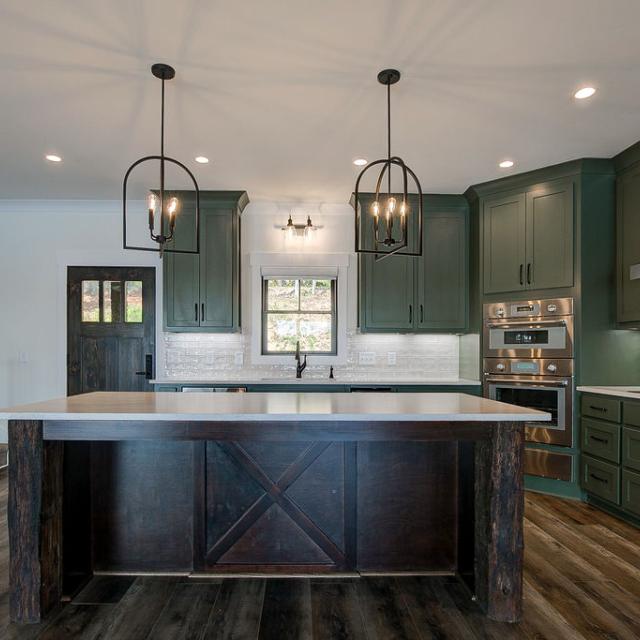 Custom Rafter B kitchen featuring stone countertops and stainless steel appliances in a lakeside home