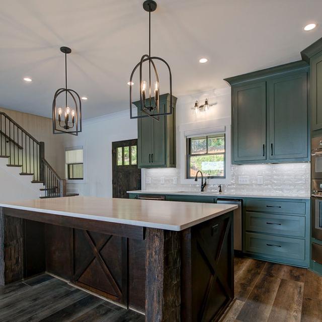 Custom Rafter B kitchen featuring stone countertops and stainless steel appliances in a lakeside home