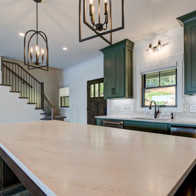 Custom Rafter B kitchen featuring stone countertops and stainless steel appliances in a lakeside home