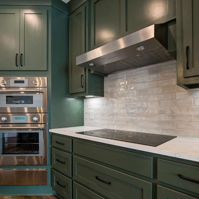 Custom Rafter B kitchen featuring stone countertops and stainless steel appliances in a lakeside home