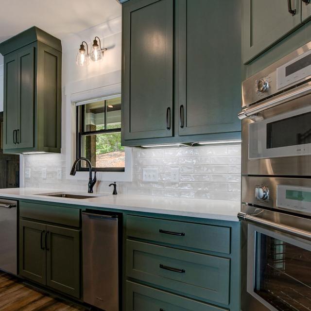 Custom Rafter B kitchen featuring stone countertops and stainless steel appliances in a lakeside home