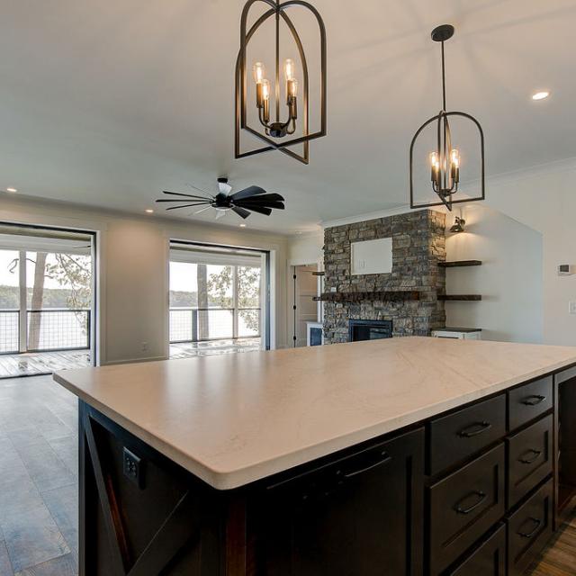 Custom Rafter B kitchen featuring stone countertops and stainless steel appliances in a lakeside home