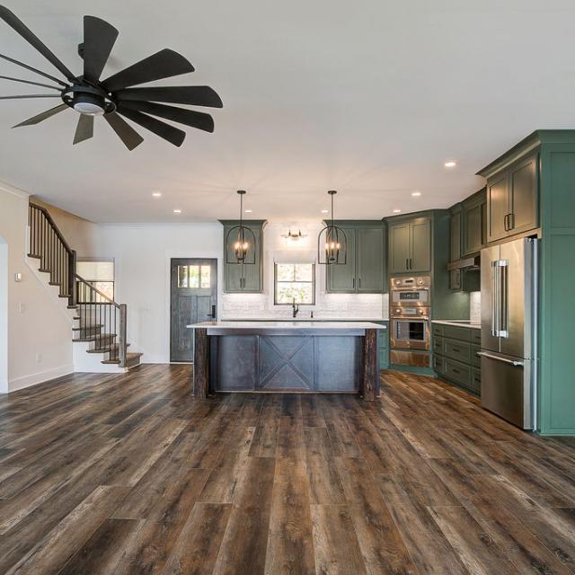 Custom Rafter B kitchen featuring stone countertops and stainless steel appliances in a lakeside home