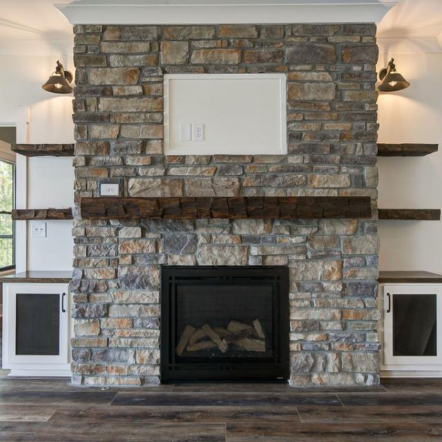 Custom Rafter B living room featuring stone fireplace 