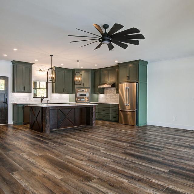 Custom Rafter B kitchen featuring stone countertops and stainless steel appliances in a lakeside home