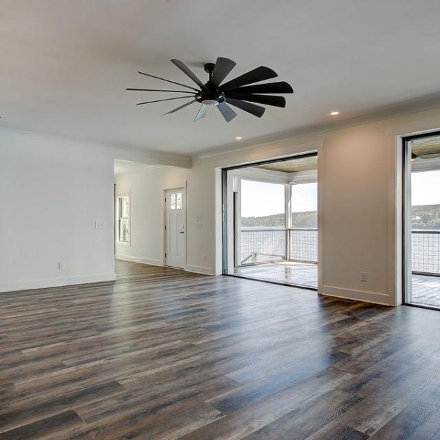 Custom Rafter B living room featuring large open sliding glass doors in a lakeside home