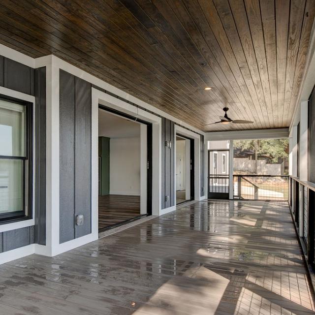 Screened porch on rear of custom home featuring wooden floors and ceiling and large sliding glass doors