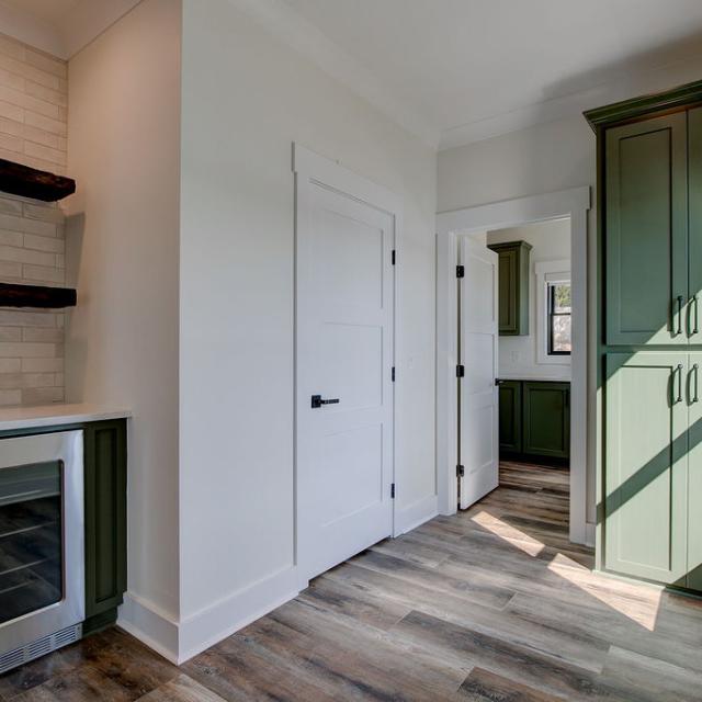 Interior hallway with built-in cabinetry and wooden floors and beverage cooler