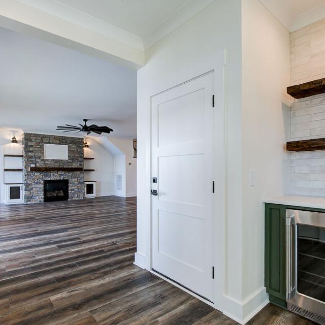 Interior hallway with built-in cabinetry and wooden floors and beverage cooler