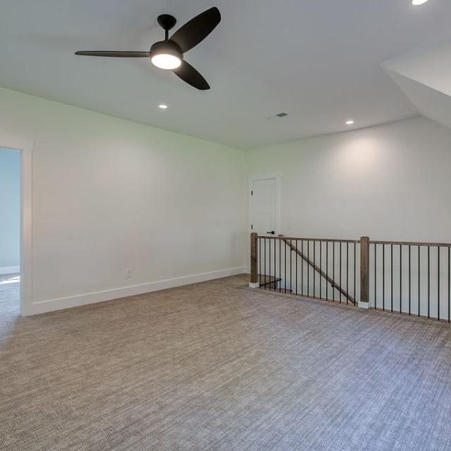 Carpeted interior room with railing