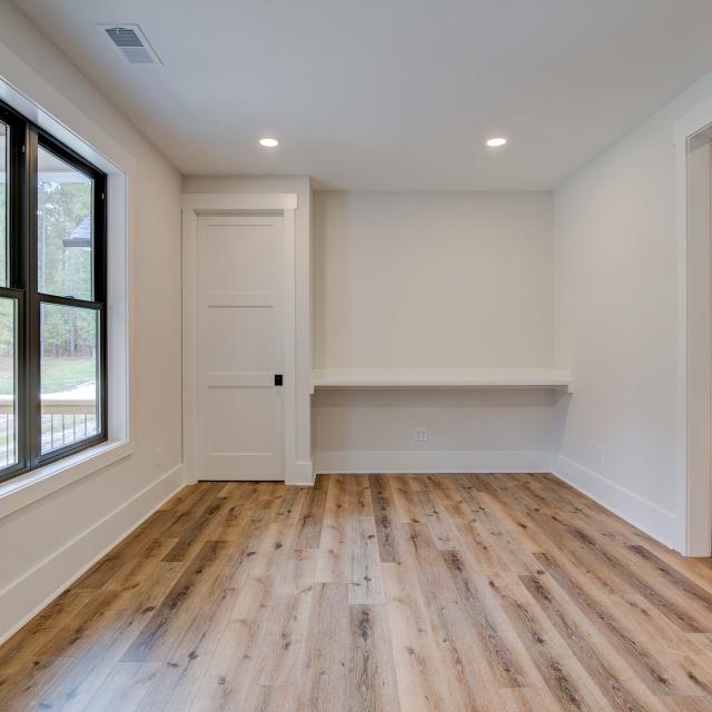 Room with white walls and wooden floors - Rafter B Construction custom home