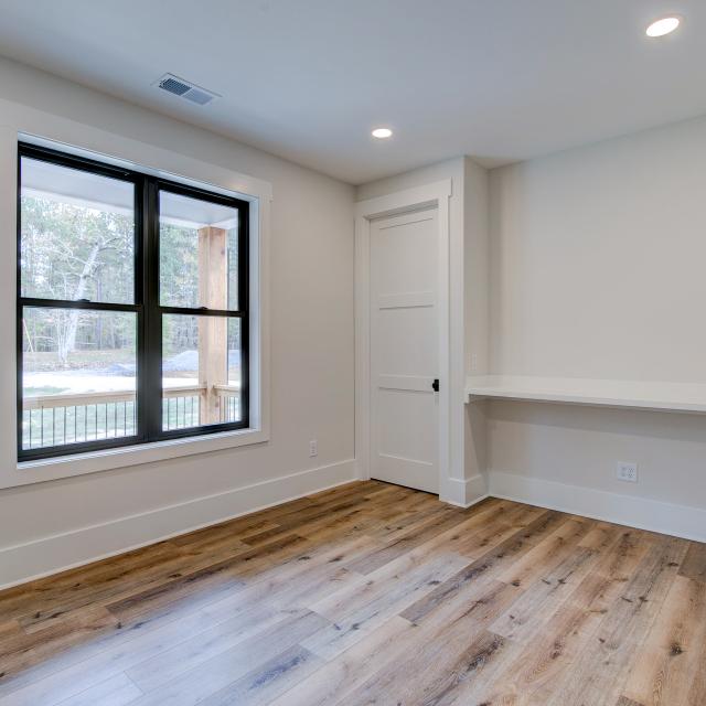 Room with white walls and wooden floors - Rafter B Construction custom home