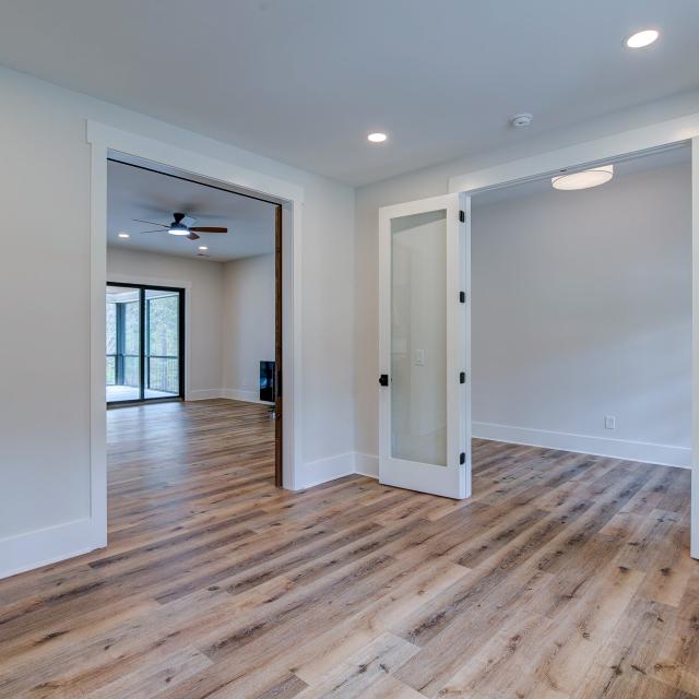 Room with white walls and wooden floors - Rafter B Construction custom home