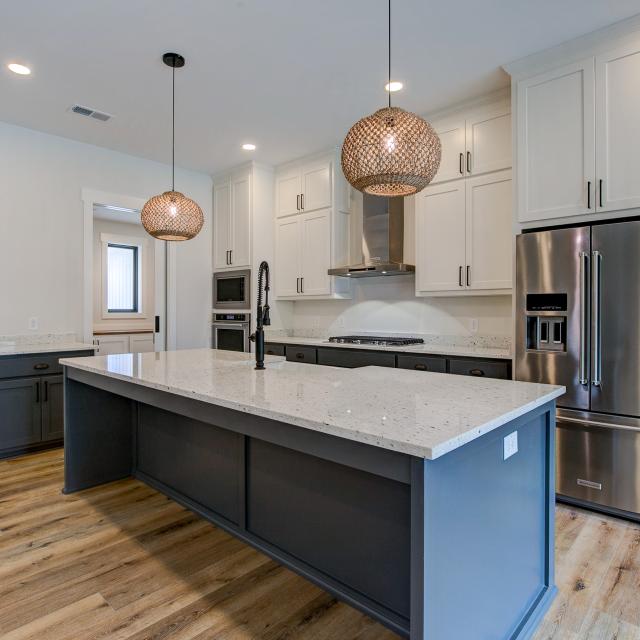 Open concept kitchen with white cabinets and large island - Rafter B Construction custom home