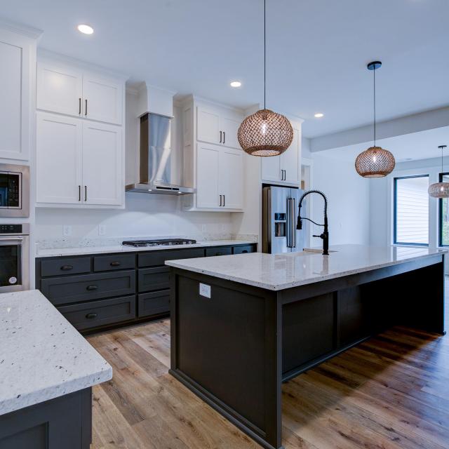 Open concept kitchen with white cabinets and large island - Rafter B Construction custom home