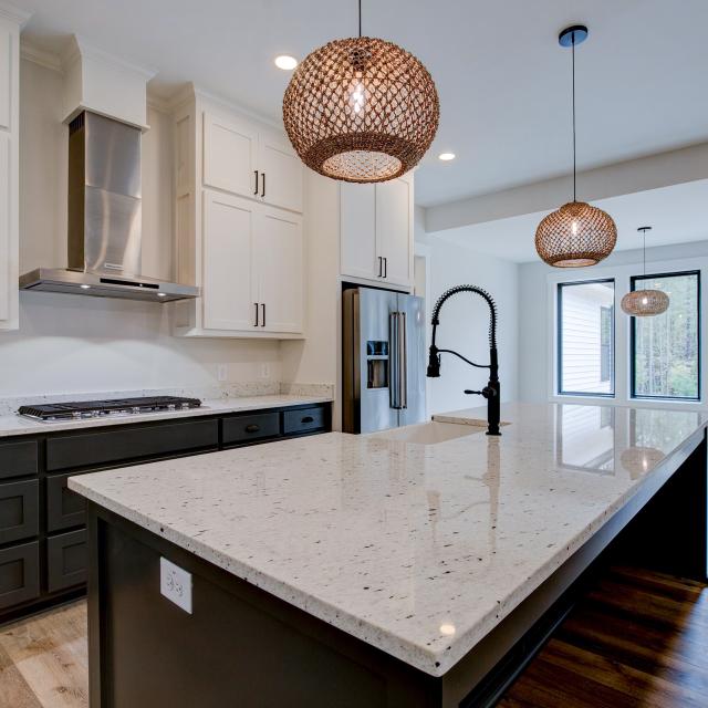 Open concept kitchen with white cabinets and large island - Rafter B Construction custom home