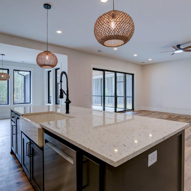 Open concept kitchen with white cabinets and large island - Rafter B Construction custom home