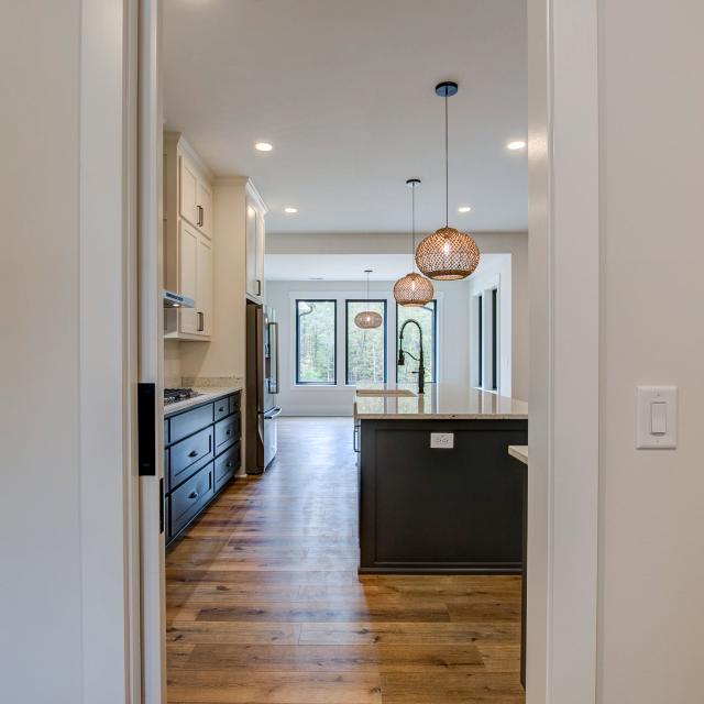 Open concept kitchen with white cabinets and large island - Rafter B Construction custom home