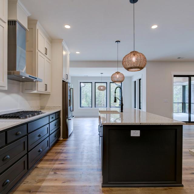 Open concept kitchen with white cabinets and large island - Rafter B Construction custom home