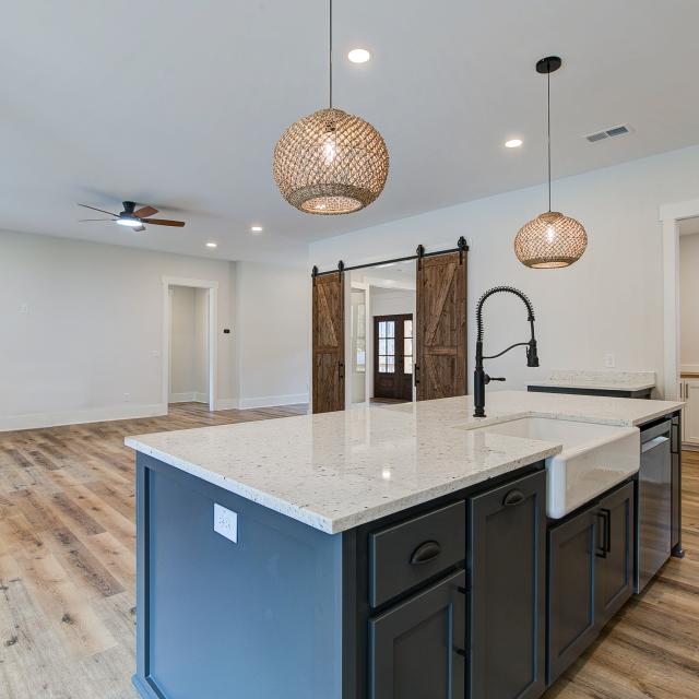 Open concept kitchen with white cabinets and large island - Rafter B Construction custom home