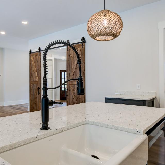 Open concept kitchen with white cabinets and large island - Rafter B Construction custom home