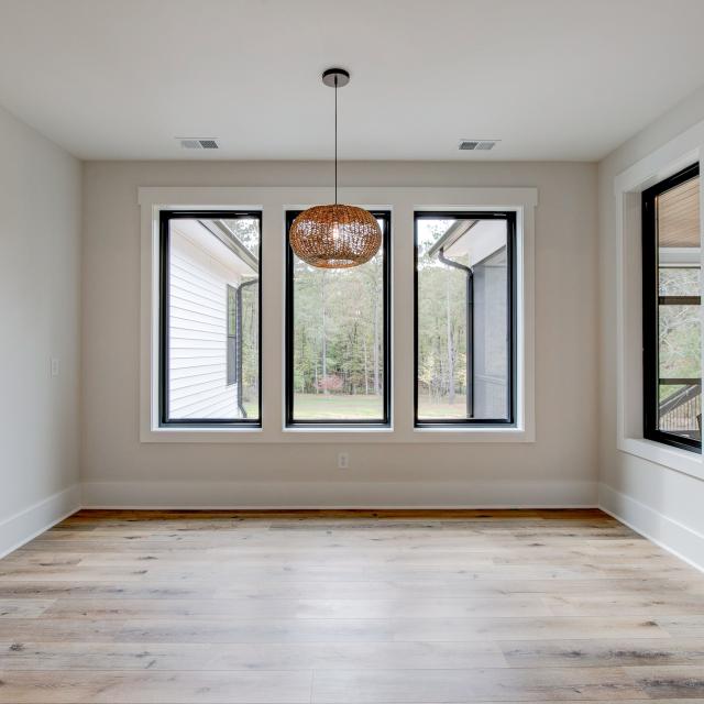 Dining room with wood floors, white walls and large windows