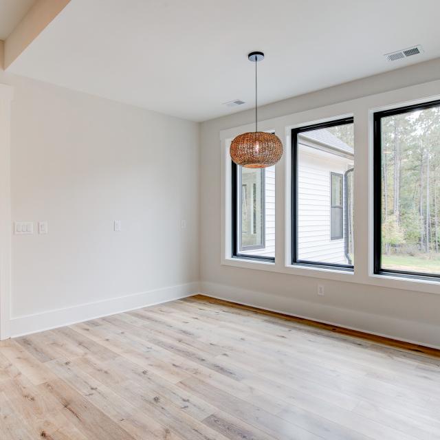 Dining room with wood floors, white walls and large windows