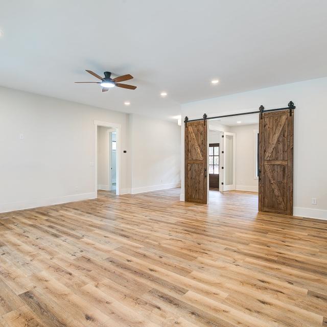 Room with wood floors, white walls and large windows