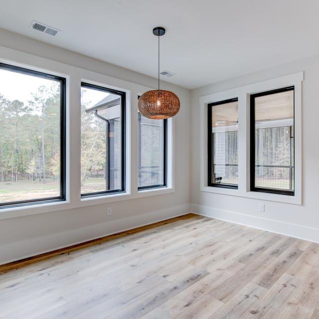 Dining room with wood floors, white walls and large windows