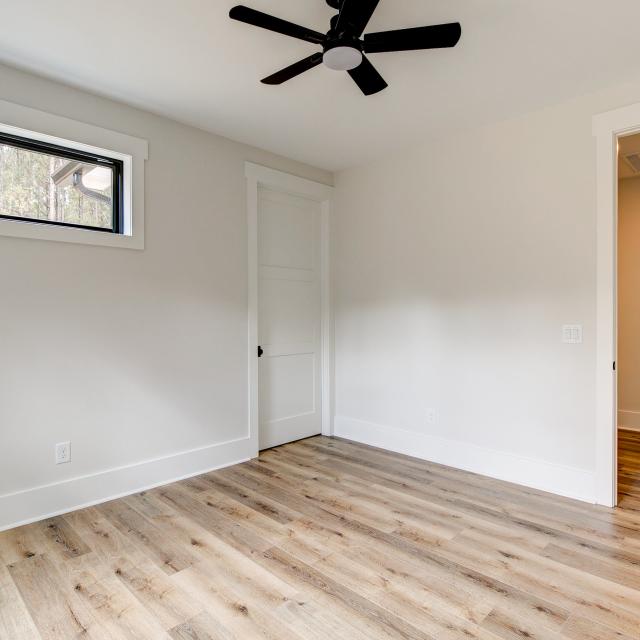 Room with wood floors, white walls and ceiling fan