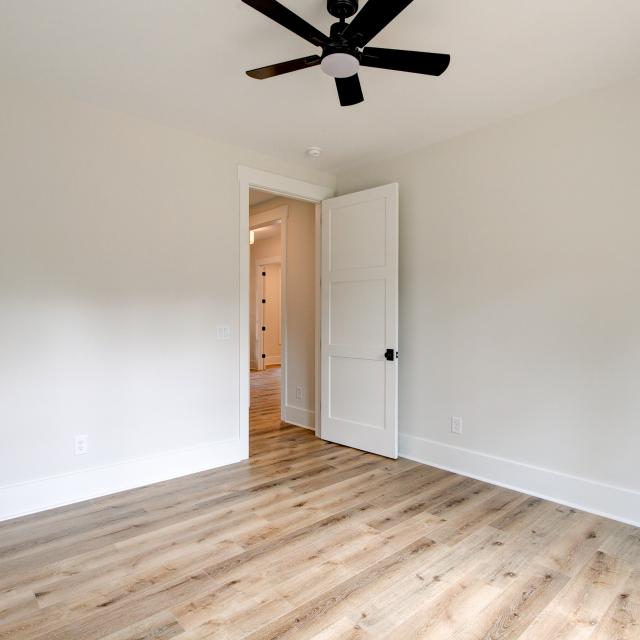 Room with wood floors, white walls and ceiling fan